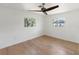 Bright bedroom with wood floors, ceiling fan, and windows offering outdoor views at 609 Glen Oak Rd, Venice, FL 34293