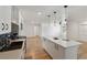 A modern kitchen features white cabinets, a center island, stainless steel appliances, and hardwood floors at 609 Glen Oak Rd, Venice, FL 34293