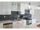 Well-equipped kitchen featuring modern appliances, hexagon backsplash, and contemporary lighting at 609 Glen Oak Rd, Venice, FL 34293