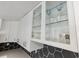 Modern kitchen cabinets with glass inserts, stainless steel appliances, and stylish hexagon backsplash at 609 Glen Oak Rd, Venice, FL 34293