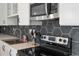 Modern kitchen featuring a black backsplash, stainless steel appliances, and a stainless steel sink at 609 Glen Oak Rd, Venice, FL 34293