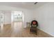 Living room with wood floors, wicker chair, and view into sunny second room at 609 Glen Oak Rd, Venice, FL 34293