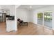 Bright living room with sliding glass doors and wood floors, seamlessly flowing into kitchen area at 609 Glen Oak Rd, Venice, FL 34293