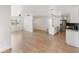 A bright and airy living space featuring hardwood floors, white walls, and an open kitchen at 609 Glen Oak Rd, Venice, FL 34293