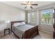 Comfortable bedroom with a wooden bed frame, two windows offering natural light and outside views at 6124 35Th E Ct, Bradenton, FL 34203