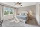 Sunlit bedroom with a tufted headboard bed, ceiling fan, and large window at 6124 35Th E Ct, Bradenton, FL 34203