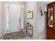 Close up of the home's tiled entryway, featuring a white door, a small table and view of dining room at 6124 35Th E Ct, Bradenton, FL 34203