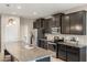 Close-up view of the modern kitchen with granite counters, dark cabinets, and stainless-steel appliances at 6124 35Th E Ct, Bradenton, FL 34203