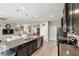 Contemporary kitchen showcasing a large island with bar seating, stainless steel appliances and dark cabinetry at 6124 35Th E Ct, Bradenton, FL 34203