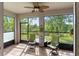 Outdoor screened porch featuring comfortable chairs, glass table, ceiling fan, and green backyard views at 6124 35Th E Ct, Bradenton, FL 34203