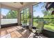 Screened in porch featuring a fan, tile floors, a table with chairs, and beautiful views of the backyard at 6124 35Th E Ct, Bradenton, FL 34203