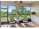 Inviting screened-in porch with a ceiling fan, comfortable seating, and peaceful views of the green outdoors at 6124 35Th E Ct, Bradenton, FL 34203