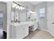 Bright bathroom featuring double sinks, a makeup vanity, and neutral-toned tile flooring at 6312 67Th E St, Bradenton, FL 34203
