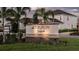 Community sign for Tiburon Sarasota with palm trees and residential homes in the background at 6908 Prairie Oak Way, Nokomis, FL 34275