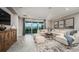 Open-concept living room with modern decor, a sectional sofa, and large windows for natural light at 6908 Prairie Oak Way, Nokomis, FL 34275
