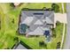 Aerial view of the property showcasing the screened pool, landscaped yard, and roof at 7034 Honeysuckle Trl, Lakewood Ranch, FL 34202
