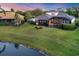 Expansive backyard with lush lawn, screened pool, and picturesque pond view, offering privacy and tranquility at 7034 Honeysuckle Trl, Lakewood Ranch, FL 34202