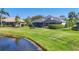 Beautiful backyard overlooking a pond, featuring lush landscaping and outdoor living space at 7034 Honeysuckle Trl, Lakewood Ranch, FL 34202