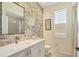 Modern bathroom featuring an accent wall, white vanity, and framed mirror at 7034 Honeysuckle Trl, Lakewood Ranch, FL 34202