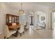 Formal dining area with modern light fixture, wooden table and seating for six at 7034 Honeysuckle Trl, Lakewood Ranch, FL 34202