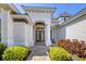 Inviting front entrance with elegant columns, a double door entry, and lush landscaping, creating a welcoming atmosphere at 7034 Honeysuckle Trl, Lakewood Ranch, FL 34202