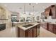 Gourmet kitchen featuring wood cabinetry, granite counters, and an eat-in island at 7034 Honeysuckle Trl, Lakewood Ranch, FL 34202