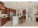 Open-concept kitchen with rich wood cabinetry, stainless steel appliances and an island with seating at 7034 Honeysuckle Trl, Lakewood Ranch, FL 34202