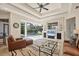 Open-concept living room with pool view through glass doors and stylish decor, ceiling fan, and fireplace at 7034 Honeysuckle Trl, Lakewood Ranch, FL 34202