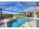 Private screened pool with spa, surrounded by lush landscaping and serene waterfront views at 7034 Honeysuckle Trl, Lakewood Ranch, FL 34202