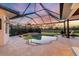 Sparkling pool and spa surrounded by a screened lanai with views of the pond and landscape at 7034 Honeysuckle Trl, Lakewood Ranch, FL 34202