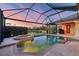 Screened-in pool and hot tub offering serene views of the lush landscaping and waterfront beyond at 7034 Honeysuckle Trl, Lakewood Ranch, FL 34202