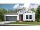 Charming single-story home with a two-car garage, manicured lawn, and inviting front entrance at 7048 Foxboro Way, Nokomis, FL 34275