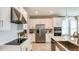 Well-equipped kitchen with stainless steel appliances, elegant white cabinetry, and a breakfast bar at 7048 Foxboro Way, Nokomis, FL 34275