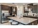 Beautiful kitchen with stainless steel appliances, dark wood cabinets, island, and pendant lighting at 7052 Foxboro Way, Nokomis, FL 34275