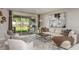 Bright and airy living room with sliding glass doors leading to the outdoor patio and grill at 7052 Foxboro Way, Nokomis, FL 34275