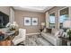 Cozy living room with desk space boasts large windows, neutral decor, and an area rug at 7052 Foxboro Way, Nokomis, FL 34275