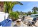 Inviting backyard features lounge chairs, a fire pit, and lush tropical landscaping by the water at 7142 Hawks Harbor Cir, Bradenton, FL 34207
