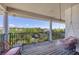 Covered balcony with lounge chair, hanging swing seat, and views of greenery and water at 7142 Hawks Harbor Cir, Bradenton, FL 34207