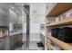 Modern bathroom with glass shower, double sink vanity, and wood storage shelves at 7142 Hawks Harbor Cir, Bradenton, FL 34207