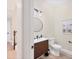 Half bathroom featuring modern vanity, round mirror, and artistic wall decor at 7142 Hawks Harbor Cir, Bradenton, FL 34207