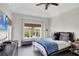 Well-lit bedroom features a ceiling fan, large window overlooking trees, and comfortable furnishings at 7142 Hawks Harbor Cir, Bradenton, FL 34207