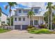 Elegant two-story home with well-manicured lawn, mature palm trees, and a charming front entrance at 7142 Hawks Harbor Cir, Bradenton, FL 34207
