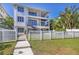 Exterior home shot showing stairs from backyard pool area, multiple decks, and neatly kept lawn with a privacy fence at 7142 Hawks Harbor Cir, Bradenton, FL 34207