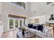 Bright living room featuring a sectional sofa, large windows, and an open connection to the kitchen at 7142 Hawks Harbor Cir, Bradenton, FL 34207