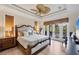 Comfortable main bedroom showcases a large bed, ceiling fan, and access to a private balcony at 7142 Hawks Harbor Cir, Bradenton, FL 34207