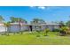 Charming single-story home featuring a well-manicured lawn, mature trees, and solar panels on the roof at 959 Cumberland Rd, Venice, FL 34293