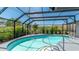 Screened pool with clear water surrounded by lush landscaping and seating at 959 Cumberland Rd, Venice, FL 34293