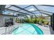 Enclosed pool area with patio furniture, shade, landscaping, and clear blue water at 959 Cumberland Rd, Venice, FL 34293