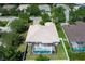 Aerial view of a single-story home with a screened pool enclosure, surrounded by a well-maintained yard and mature trees at 11458 30Th E Cv, Parrish, FL 34219