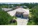 Aerial view of a charming single-story home featuring a tile roof, well-kept landscaping, and a spacious driveway at 11458 30Th E Cv, Parrish, FL 34219